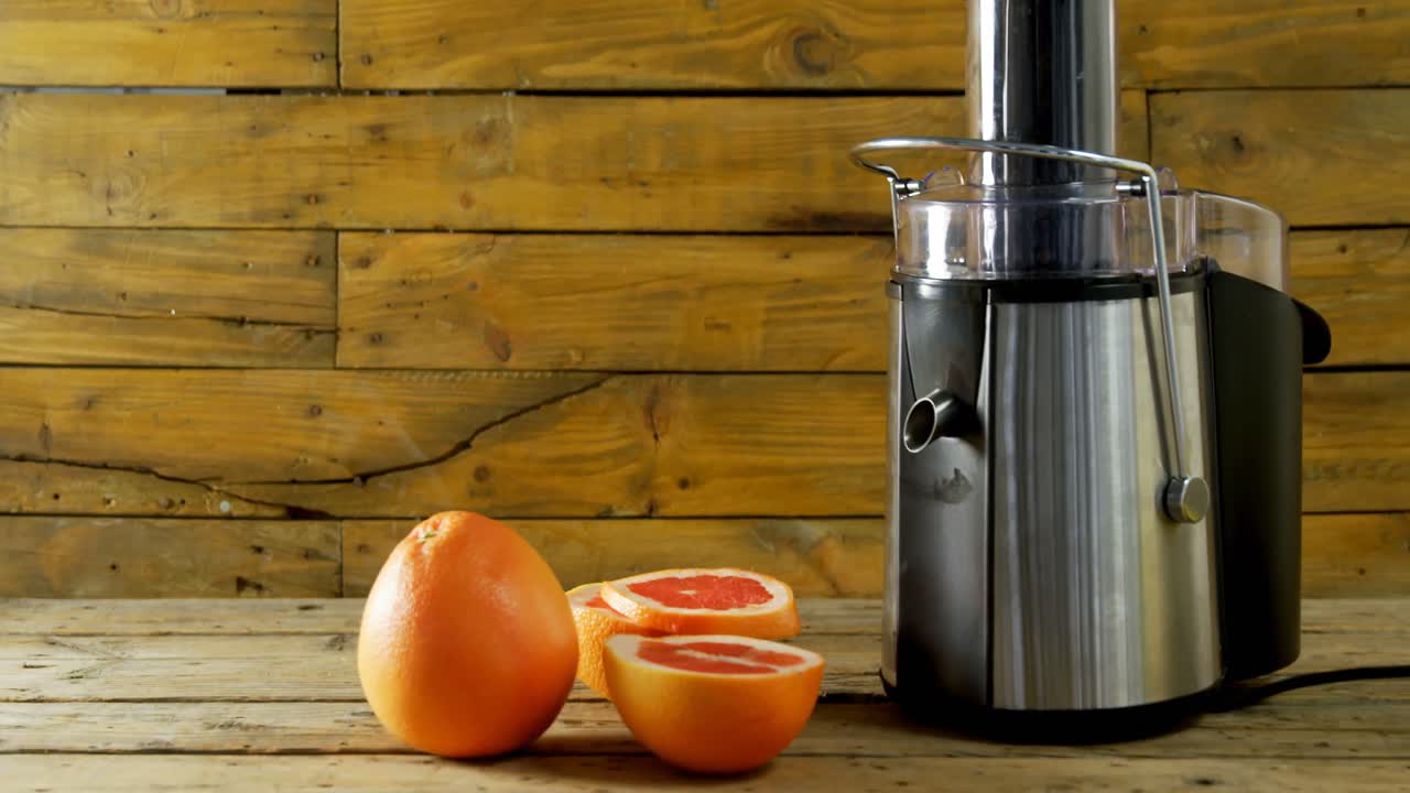 toronja y fabricante de jugo en una mesa de madera 4k