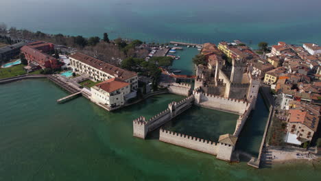 aerial view of historic medieval scaligero castle in sirmione, lombardy, italy on lake garda, drone shot
