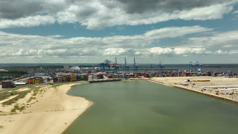 Aerial-view-of-the-Gdańsk-harbor,-highlighting-the-bustling-container-port-with-numerous-shipping-containers-and-large-cranes