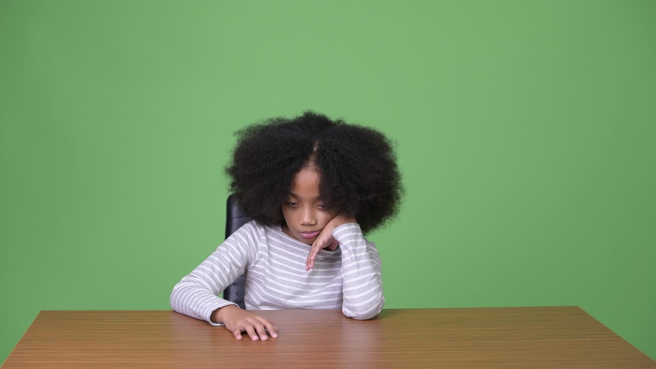 Giovane ragazza africana carina con capelli afro annoiata.