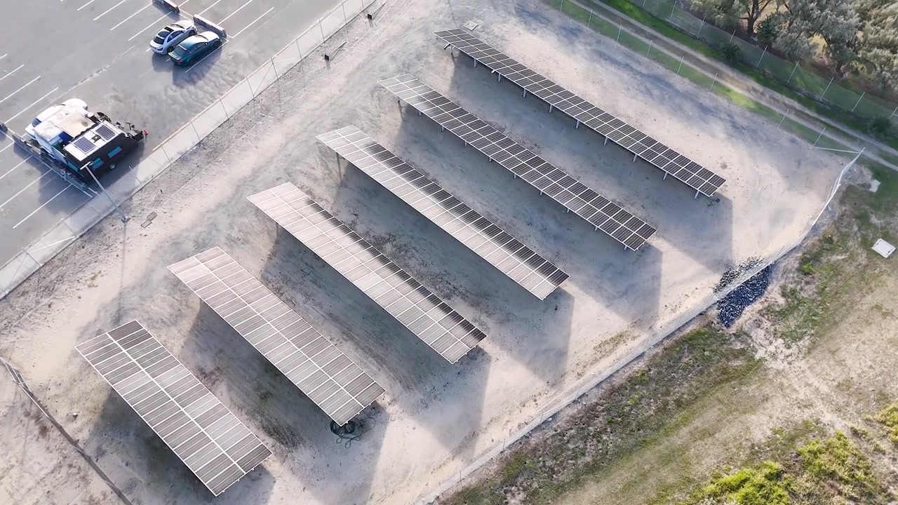 Ripresa aerea con drone di pannelli solari fotovoltaici sopra un'area di parcheggio a Surfers Paradise, Australia