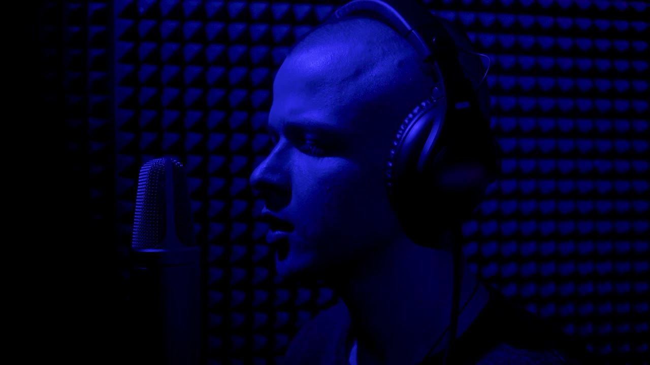 hombre cantando en un micrófono en un estudio de grabación