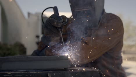 la persona sta saldando un oggetto metallico nel cantiere