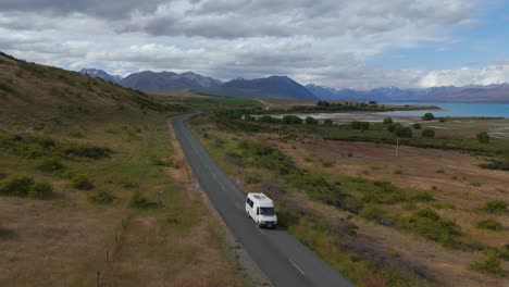 Camper-Van-driving-near-Lake-Tekapo-aerial-view-from-drone