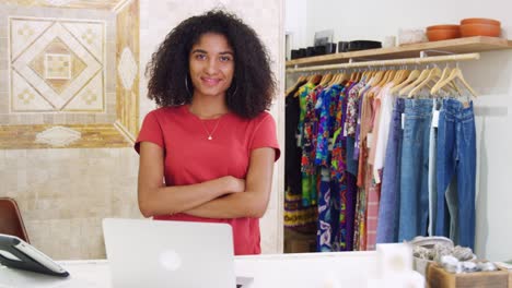 portrait of female owner of independent clothing and gift store behind sales desk