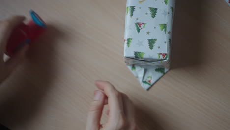 party organizer, tightly wrapping the gift box with decorative paper and cello tape