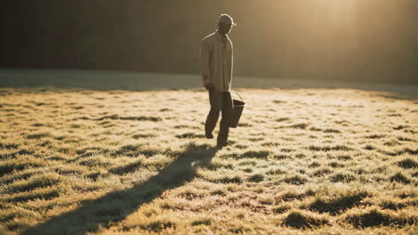 person holding a bucket in a sunny field