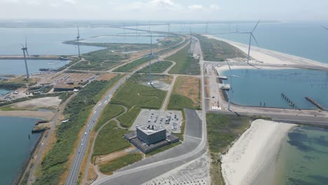 Dutch-storm-surge-barrier-with-wind-turbines,-Delta-Park-Neeltje-Jans-aerial