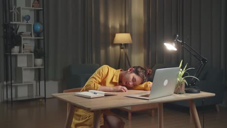 tired student sleeping at desk at night