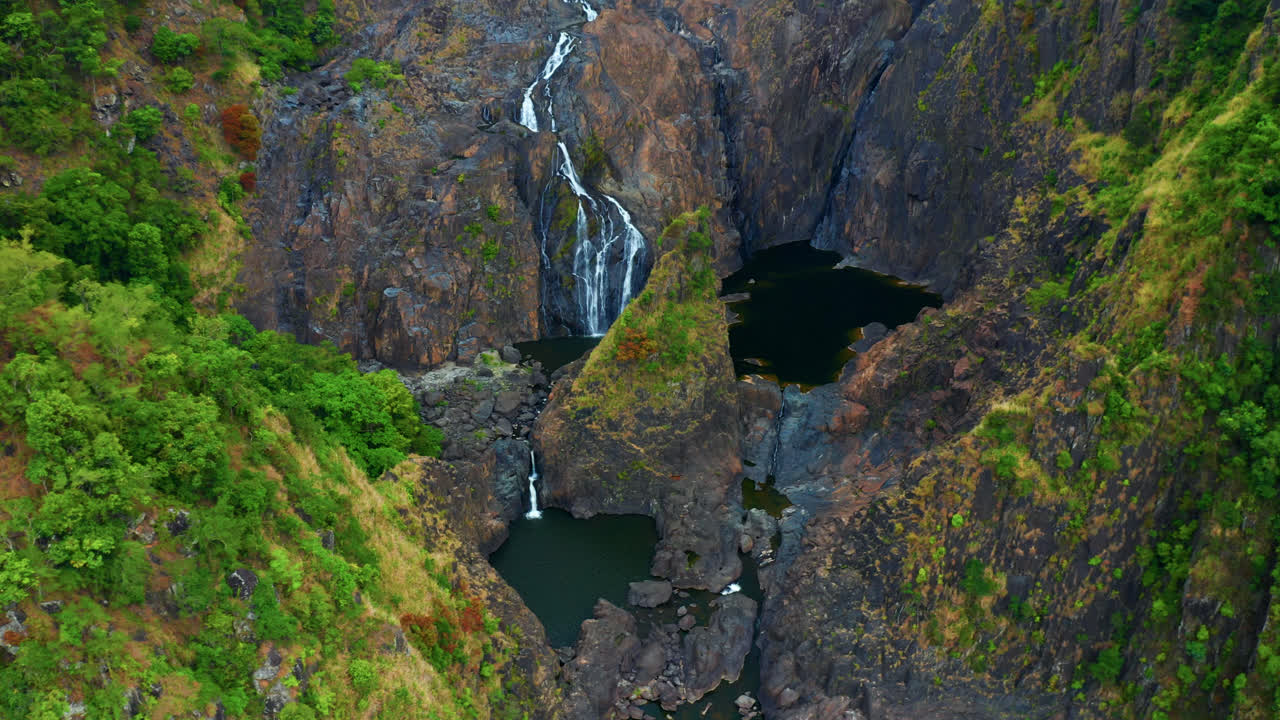 vista aérea de la cascada que cae sobre escarpados acantilados en kuranda, queensland, australia - disparo de drones