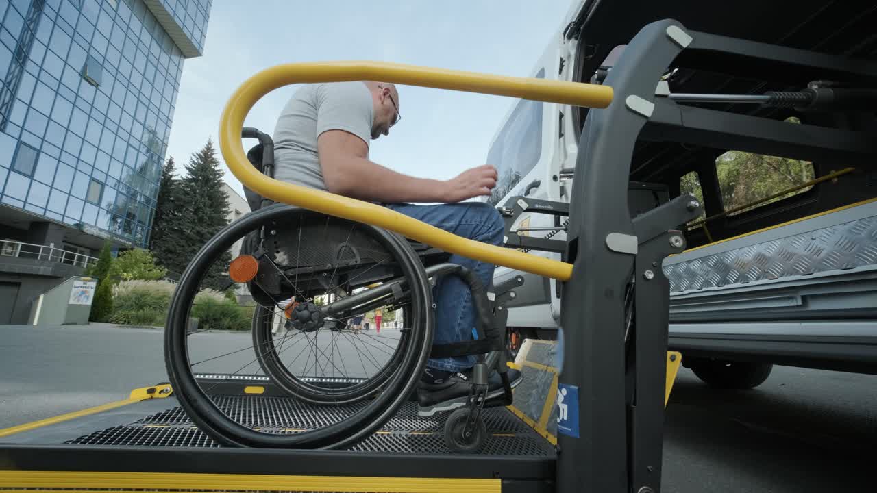 A man in a wheelchair on a lift of a vehicle for people with disabilities. Lifting equipment for people with disabilities - man in wheelchair near the vehicle