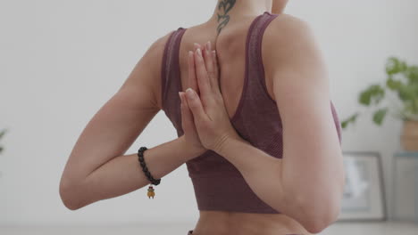 yogi haciendo una postura con las manos detrás de la espalda