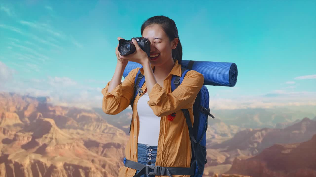 Asian Female Hiker With Mountaineering Backpack Using A Camera Taking Picture While Traveling At The Top Of Mountain