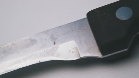 knife with black handle and short blade on white background