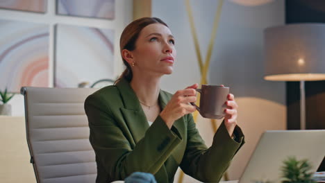 Manager holding coffee cup resting in office closeup. Pensive woman thinking