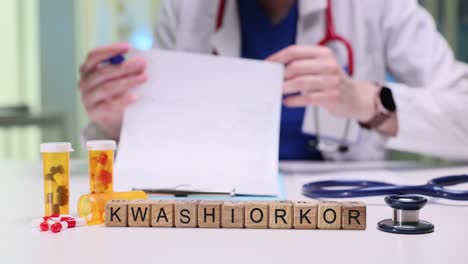 medical professional with 'kwashiorkor' blocks, medicine, and stethoscope