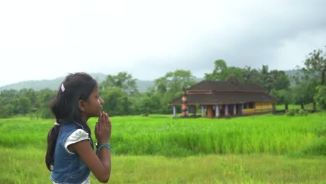 little girl praying  near temple  farm malvan maharashtra