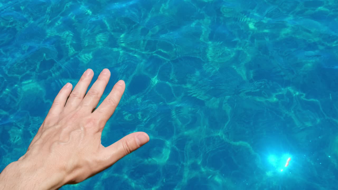 Hand reaching out to touch the water