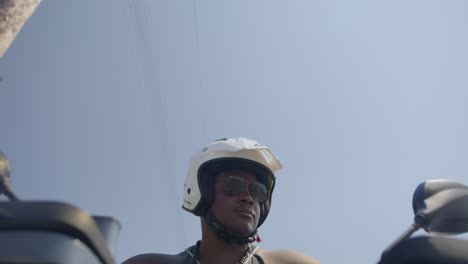 hombre negro conduciendo una motocicleta en la calle, policía de playa, aplicación de la ley, pobreza, 4k | mirando a su alrededor, temblando, carretera, viajes, viendo a los coches pasar por multas de exceso de velocidad