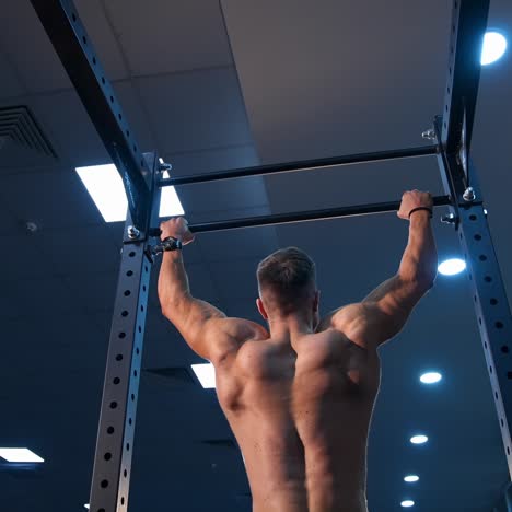 handsome man gumped on horisontal bar. male sportsman trains in gym. slow motion