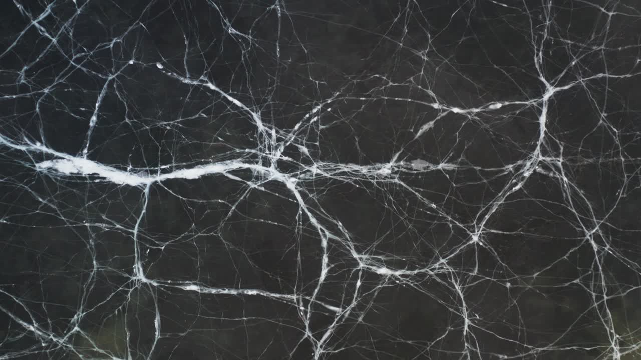 겨울 얼어붙은 호수 표면에 흰색 선 균열, 위에서 아래로