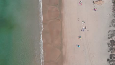 top down still view of the são torpes beach with the waves calmly splashing on the shore