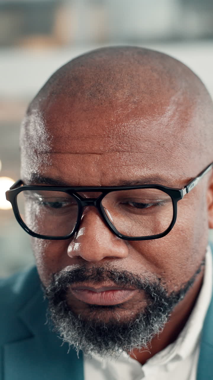 African American Businessman Puts on Glasses and Looks Down