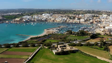 panoramic view of boats in the harbor of mediterranean fishing village in marsaxlokk, south eastern region of malta