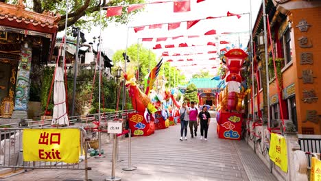 people walking through colorful temple entrance