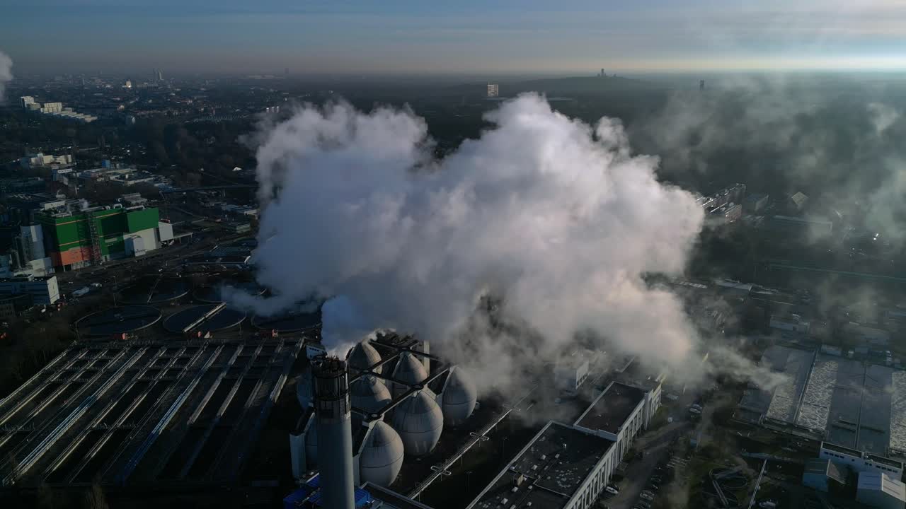 Ciminiere di una centrale elettrica industriale che rilasciano grandi pennacchi di fumo inquinante nell'atmosfera, contribuendo al danno ambientale. Splendida vista aerea panoramica con drone