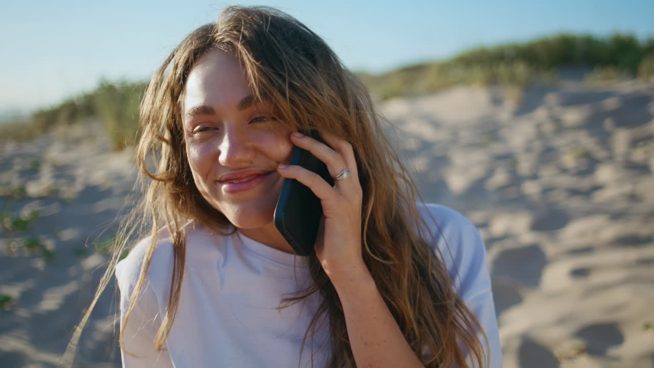 Smiling woman calling beach on sunny day closeup. Relaxed girl talk smartphone
