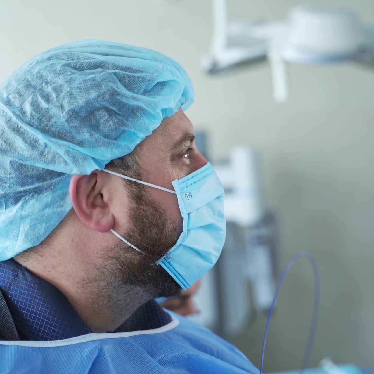 Handsome surgeon in blue medical mask operating. Close up view of surgery operation