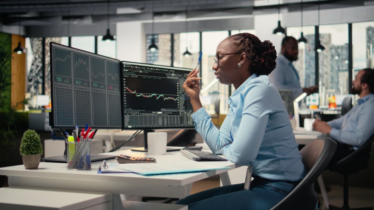 Forex expert in office looking over candlestick charts on screen