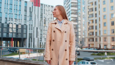 excited woman looking surprised clenching fists shocked by sudden victory standing on city street