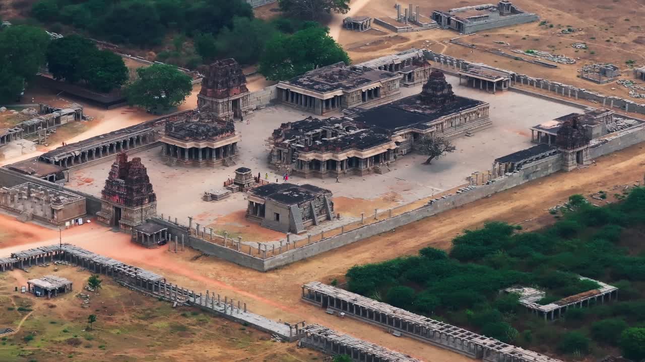 Rovine del tempio Shri Achyutaraya Swamy con alberi a Vijayanagara, Hampi, Karnataka, India. Di giorno, ripresa stabile, ripresa da drone, 4K.