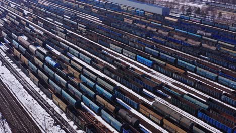 de vastes rangées de matériel roulant attendent dans la gare de triage près de katowice en pologne - drone aérien suivi de gauche à droite - paysage industriel d'hiver couvert de neige