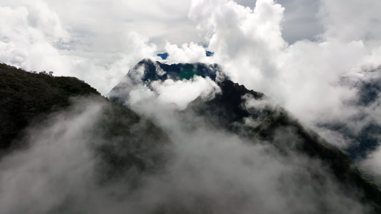 Vista aerea di una cima montuosa che emerge da un mare di fitta nebbia e nuvole vicino a Machu Picchu, Perù.