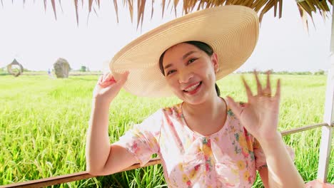 asian woman making video call showing large rice production field