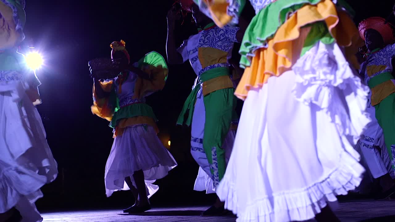 Group of colorful dancers performing the traditional Caribbean dance of Curacao at night time