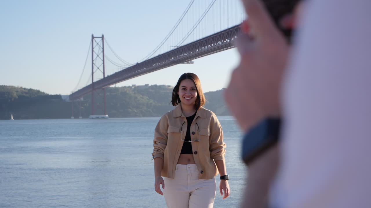 Influencer in posa per una foto davanti a un famoso ponte a Lisbona, Portogallo.