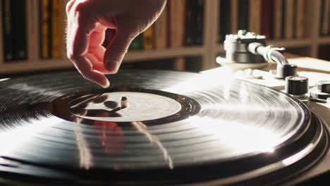 hand playing a vinyl record on a turntable
