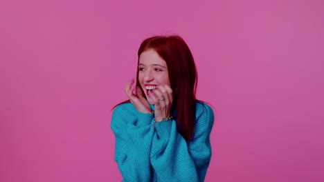 teen girl in blue sweater shouting, raising fists in gesture i did it, celebrating success, winning