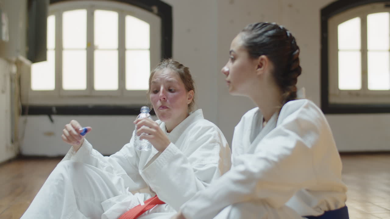 체육관에서 가라데 훈련 후 휴식을 취하는 소녀들의 모습