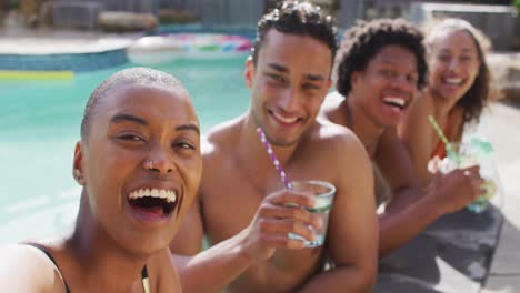 Grupo-De-Diversos-Amigos,-Hombres-Y-Mujeres,-Haciendo-Tostadas-Con-Bebidas-Y-Riendo-En-La-Piscina