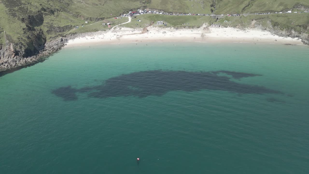 Stille vann i Atlanterhavet som omgir den pittoreske Keem Beach og den fremtredende øya Achill i Irland.
