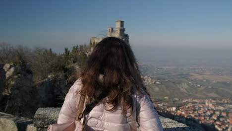 chica mirando un castillo y una vista de la ciudad