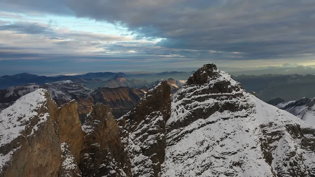disparo de un dron volando sobre las cimas de una montaña desnuda, fría y cubierta de nieve en la naturaleza remota y aislada de suiza