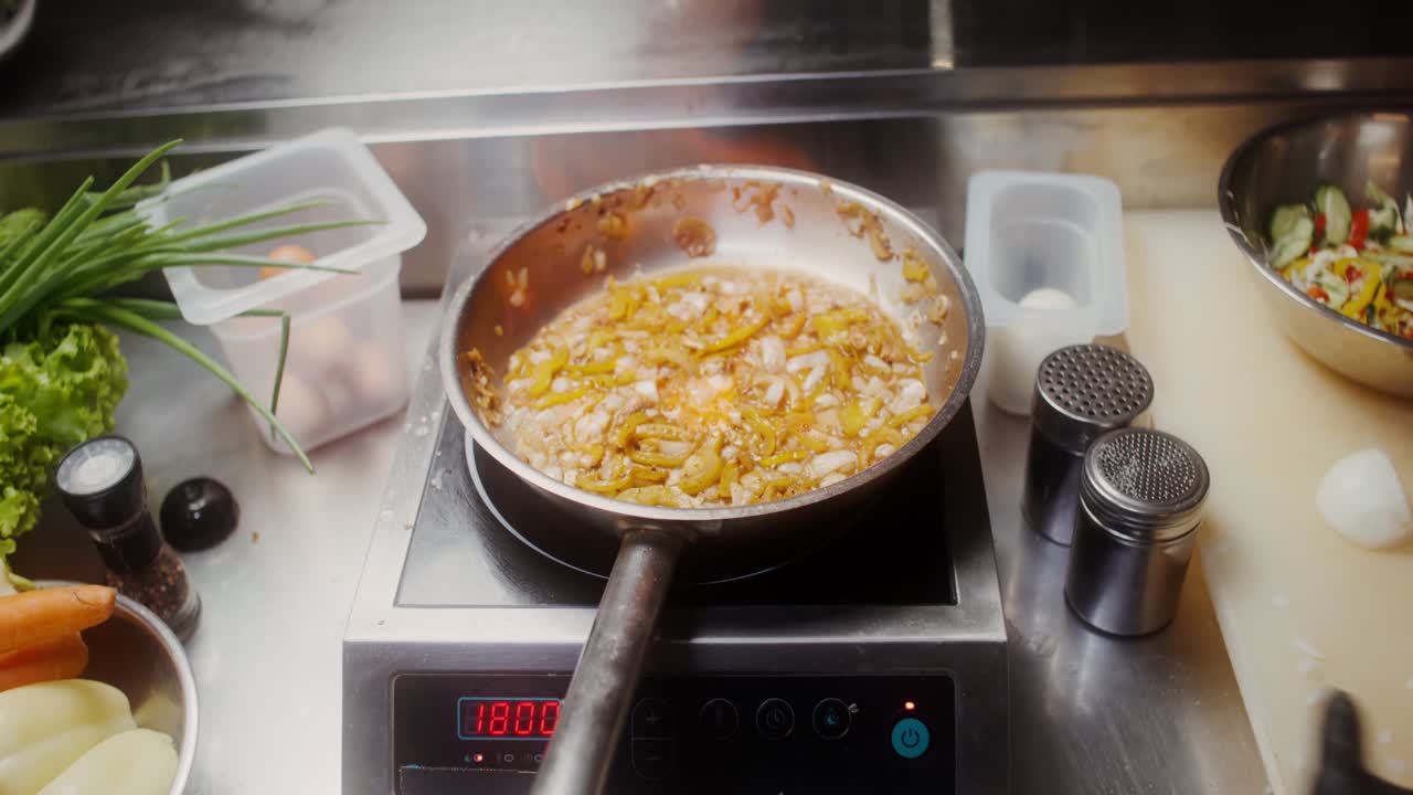 요리사 가 판 에 채소 를 조리 하고 있다