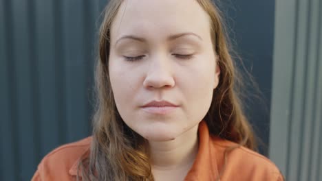 tired brunette looking to camera and blinking a lot, close up portrait view