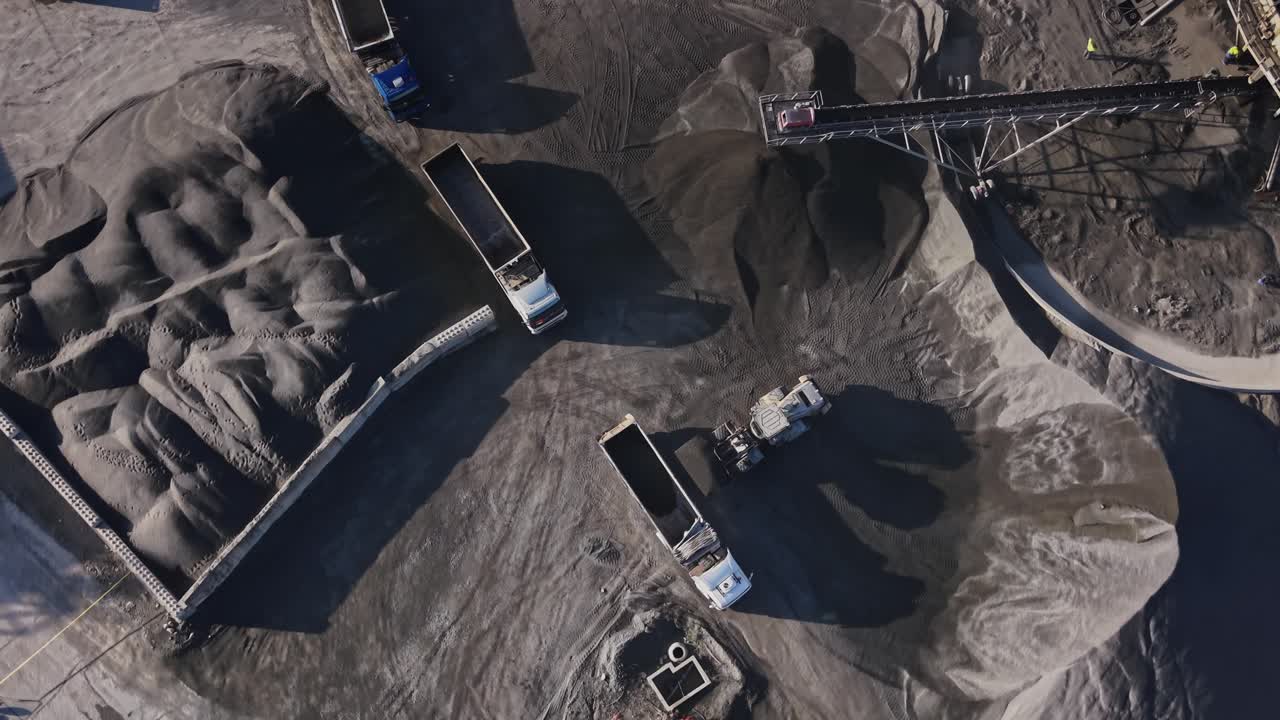 Quarry operation with trucks transporting material at mining site
